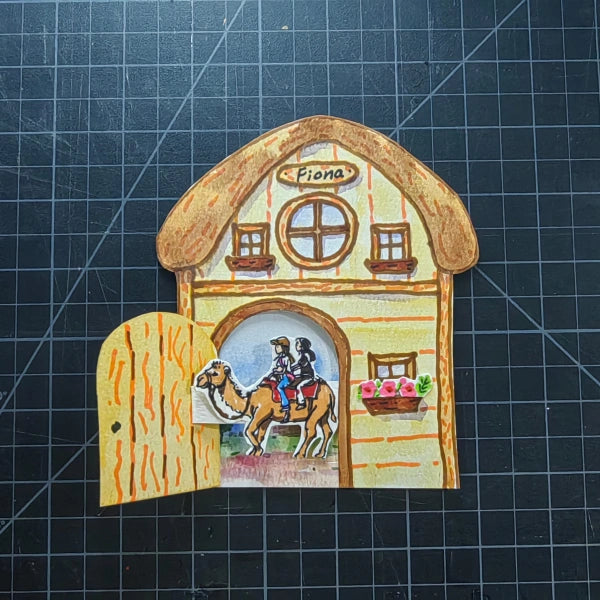Die-cut house watercolor keepsake card with open door revealing custom illustration of friends on a camel